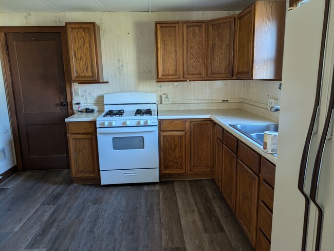 Kitchen has laminate wood floor, gas range and refrigerator/freezer - 3 N Atkins Ave