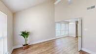 This two-story townhouse in Hammond, Louisiana offers three bedrooms and two and a half bathrooms across a well-designed, generously sized floor plan. The main living area immediately impresses with its dramatic vaulted ceilings that soar overhead, amplifying the sense of space and openness. Wood-look plank flooring runs throughout the main level, complementing the warm, neutral color palette of the walls. A ceiling fan keeps the living space comfortable, while multiple windows allow abundant natural light to fill the room. A staircase with a clean white railing leads to the upper level. The kitchen is fully equipped with warm wood cabinetry, granite-style countertops, a double basin sink, and white appliances including a refrigerator, range, microwave, and dishwasher — all set on matching wood-look flooring. A convenient half bath on the main level features a wood-cabinet vanity with a granite-style countertop and a large mirror. Upstairs, the bedrooms are carpeted and well-lit by windows with blinds, providing a quiet and comfortable retreat. Each bedroom includes a ceiling fan for added comfort. The overall ambiance of this townhouse is clean, bright, and move-in ready, offering a practical and inviting living environment.