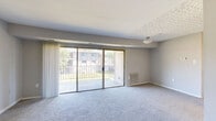 Located at 6500 Ronald Rd in Capitol Heights, MD, this one-bedroom, one-bathroom residence offers a well-organized single-floor layout designed for comfortable everyday living. The living area is bright and open, featuring plush carpeting, neutral gray walls, and large sliding glass doors that flood the space with natural light and open directly onto a private balcony. The balcony overlooks a landscaped lawn with mature trees, providing a peaceful outdoor retreat with pleasant views of the surrounding community. The kitchen is equipped with a gas range, warm wood-toned cabinetry, and easy-to-maintain tile-style flooring. A louvered bi-fold closet door provides convenient pantry or utility storage, and a windowed partition adds a touch of character to the space. The bedroom is a comfortable, carpeted room with a large window that brings in natural light and offers views of the greenery outside. It connects to a spacious walk-in closet outfitted with built-in shelving on multiple walls, offering ample storage capacity. The bathroom features a full-sized soaking tub with tiled surround, a vanity with a white countertop, and tile flooring. Clean, neutral finishes throughout the unit create a cohesive and move-in-ready atmosphere.