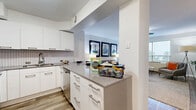 Located at 910 Pennsylvania Ave in Kansas City, MO, this one-bedroom, one-bathroom residence offers a thoughtfully designed single-level layout. The open-concept kitchen and living area serves as the heart of the unit, where the kitchen impresses with sleek white cabinetry, a herringbone-patterned tile backsplash, quartz countertops, stainless steel appliances — including a refrigerator, range, and microwave — and wood-look flooring. A peninsula with bar seating provides a casual dining option and a natural transition into the living space. The living room is bright and airy, featuring large windows that invite natural light and offer views of the surrounding cityscape. A ceiling fan adds comfort, while the open layout provides a versatile and welcoming atmosphere. The bedroom is a calm retreat, appointed with plush carpeting, wide windows, and ample space for a full suite of furnishings. The bathroom is clean and functional, featuring white tile surround in the tub and shower combo with chrome fixtures. Throughout the unit, the neutral color palette and modern finishes create a cohesive, contemporary aesthetic well-suited to urban living in the heart of Kansas City.
