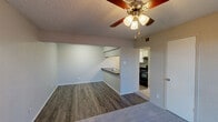 Located at 2425 S 21st St in Waco, Texas, this 2-bedroom, 2-bathroom single-story home offers a practical and well-organized layout across a compact footprint. The living area features durable wood-look flooring and a ceiling fan with light fixture overhead, creating a comfortable everyday space. It opens directly to the kitchen via a peninsula-style breakfast bar topped with dark countertops, providing both a casual dining area and additional prep space. The kitchen is equipped with black appliances, including a refrigerator and electric range, white cabinetry, and upper shelving for ample storage. Both bedrooms are carpeted and include ceiling fans; the primary bedroom is a well-proportioned room with a natural light window and access to a spacious walk-in closet featuring dual hanging rods and a central shelving unit. The second bedroom also benefits from natural light and a closet with sliding doors. Each bathroom includes a full tub-shower combo with a white surround, with one bathroom featuring wood-look flooring and a dark-topped vanity. Textured walls and ceilings are consistent throughout the home, adding a layer of character. A hallway connects the private areas, keeping the layout efficient and functional.