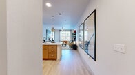 This thoughtfully designed one-bedroom, one-bathroom residence offers an efficient and stylish single-floor layout that maximizes every square foot. Light wood-style flooring flows throughout the main living areas, creating a cohesive and airy feel. The open-concept kitchen and living area form the heart of the home, where warm honey-toned cabinetry, a white quartz countertop island with bar seating, and stainless steel appliances — including a range, microwave, and refrigerator — combine functionality with contemporary style. Pendant lighting above the island adds a modern accent. The living room is bright and welcoming, benefiting from large windows that invite natural light and offer outdoor views, complemented by a ceiling fan overhead. The bedroom is a comfortable retreat featuring a generous window, light-filtering blinds, and access to a well-organized walk-in closet. The bathroom includes a soaking tub with shower, tile flooring, and warm wood vanity cabinetry. Additional closet storage is plentiful throughout, with four dedicated closet spaces in total. A dedicated entrance and hallway provide a smooth transition into the living areas, rounding out this clean, modern, and efficiently planned residence.