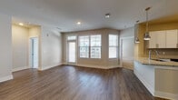 Located at Annabelle on Main in Duluth, GA, this 2-bedroom, 2-bathroom residence is designed with contemporary finishes and a functional, open-concept layout. The living area features rich hardwood-style flooring and neutral toned walls, filled with natural light from multiple windows with views of the surrounding community. A ceiling fan adds comfort to this welcoming space, which flows seamlessly into the dining and kitchen areas.

The kitchen is a standout feature, showcasing crisp white shaker cabinetry, granite countertops, a subway tile backsplash, and a full suite of stainless steel appliances including a range, microwave, dishwasher, and refrigerator. A kitchen island with a undermount sink provides additional prep space and casual dining options, complemented by stylish pendant lighting.

Both bedrooms are generously sized with plush wall-to-wall carpeting, large windows, and ample closet space, including a spacious walk-in closet with wire shelving systems. The bathrooms are finished with white cabinetry, granite-topped vanities, brushed nickel hardware, and a tub-shower combination with wood-look flooring. A dedicated in-unit laundry room accommodates a full-size washer and dryer with overhead wire shelving for added storage convenience.