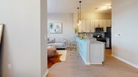 Located at 6228 Nolensville Pike in Nashville, TN, this single-floor unit offers a thoughtfully designed open-concept layout that seamlessly connects the kitchen and living areas. The kitchen is a standout feature, showcasing light wood cabinetry, granite countertops, a breakfast bar with pendant lighting overhead, and modern stainless steel appliances — ideal for both everyday cooking and casual entertaining. The living area flows naturally from the kitchen, offering a comfortable and versatile space bathed in natural light from large windows dressed with horizontal blinds that frame views of the surrounding greenery. Light wood-tone flooring runs throughout, giving the space a warm, cohesive feel. The bedroom is a serene retreat, featuring generous natural light through oversized windows, neutral wall tones, and ample room for a full furniture arrangement. The bathroom is finished with consistent granite countertops, light wood cabinetry with brushed hardware, a combined tub and shower, and wood-tone flooring that ties into the rest of the unit. A secondary flexible room provides additional space suitable for a home office, sitting room, or guest space. Overall, the unit presents a clean, modern aesthetic with quality finishes and a bright, airy ambiance throughout.
