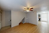 Located at 2424 Montgomery Road in Huntsville, Texas, this two-story residence offers a practical and functional layout across two well-proportioned floors. The main level features a bright, open living room with light wood-look flooring, neutral walls, and a ceiling fan with integrated lighting. Natural light filters in through a window dressed with horizontal blinds, and the staircase is neatly integrated into the living space. The kitchen is well-appointed with gray cabinetry, granite-look countertops, a tile backsplash, and stainless steel appliances including an electric range and built-in microwave. A main-level bathroom includes a vanity with stone-look countertop and a tub-shower combination with marble-style tile surround. Upstairs, two bedrooms feature plush carpeting, ceiling fans, and windows that allow in natural light. The primary bedroom offers a comfortable sense of space. A second full bathroom serves the upper level. A dedicated closet provides additional storage. The home's clean, understated aesthetic and consistent finishes throughout create a cohesive and move-in-ready living environment suitable for a variety of lifestyles.