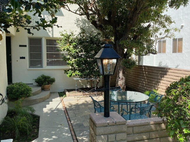 Exterior frontal/Patio de baldosas a la sombra de los árboles - 1835 Kelton Ave