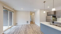 Located at 45 Fraser Blvd in Gaylord, Michigan, this thoughtfully designed 2-bedroom, 2-bathroom residence offers a functional and modern living experience on a single floor. The open-concept kitchen and living area serves as the heart of the home, featuring sleek gray cabinetry with brushed nickel hardware, white quartz countertops, stainless steel appliances, and a peninsula with pendant lighting. Light wood-look flooring flows seamlessly throughout the space, enhancing the bright, airy atmosphere created by recessed lighting and neutral wall tones. The living area opens directly to a private deck through sliding glass doors, offering pleasant wooded views. Both bedrooms are generously sized, each equipped with a ceiling fan and windows that bring in natural light and outdoor scenery. The primary bedroom includes a spacious walk-in closet outfitted with wire shelving systems for ample organization. The bathrooms feature full tub-shower combinations with brushed nickel fixtures. A dedicated laundry room houses a full-size washer and dryer, adding everyday convenience. A central hallway connects all rooms efficiently, completing this clean, modern, and comfortable layout ideal for Gaylord living.