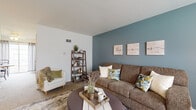 Located at 5010 Darby Rd. in Riverside, Ohio, this two-floor home offers a welcoming layout filled with personality and thoughtful design details across every room. The living area on the main floor features a bold teal accent wall, neutral carpet, and a cozy arrangement that invites relaxation. Adjacent to it, the dining area showcases a teal wainscoted wall, adding a charming, classic touch to the space. The kitchen is well-appointed with rich wood cabinetry, a subway tile backsplash, a gas range, and a peninsula breakfast bar with seating — all set atop warm hardwood flooring that flows throughout the main level. A full bathroom on this floor features tile accents and classic fixtures. Upstairs, the primary bedroom is distinguished by deep purple walls, natural light from a window with curtains, warm hardwood floors, and ample room for full bedroom furnishings. A second bedroom makes a vibrant statement with a bold orange accent wall and hardwood flooring, offering a bright and energetic atmosphere. An additional bathroom with mosaic tile detailing and vintage yellow tile flooring completes the upper level. The home's multi-floor layout, distinctive room color palettes, and hardwood floors throughout create an inviting and characterful living environment.