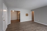 This single-floor residence at 5031 NE Chouteau Trafficway in Kansas City, Missouri, offers a well-organized layout with a clean, neutral aesthetic throughout. The open living area features light wood-style flooring, soft gray walls, and white trim, creating a bright and inviting atmosphere. A sliding glass door floods the space with natural light and provides outdoor access, while a pass-through window connects the living area to the kitchen for added convenience.

The kitchen is thoughtfully designed with white cabinetry, a white subway tile backsplash, light marble-style countertops, and stainless steel appliances including a refrigerator, electric range, and over-range microwave. Wood-style flooring continues throughout, maintaining a cohesive look.

The bedrooms are comfortably sized, each featuring plush carpeting, ceiling fans with integrated lighting, and natural light from windows. One bedroom includes a closet with built-in shelving, while another benefits from direct access to the bathroom.

The bathroom is well-appointed with a white vanity, tile-look flooring, a full tub-shower combination with a clean white surround, and a large mirror. A textured ceiling is present throughout the home, adding a classic residential touch.