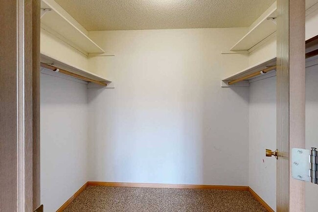 Enjoy the convenience of a walk-in closet with ample shelving and hanging space. - Northbrook Apartments