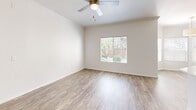 Located at 7990 E Snyder Rd in Tucson, AZ, this single-story 2-bedroom, 3-bathroom residence offers a clean, modern aesthetic throughout. The open living room is bright and airy, featuring wood-look flooring, a ceiling fan, and large windows that invite natural light and outdoor views. An arched doorway adds an architectural touch, connecting the living area to the rest of the home. The kitchen is a standout feature, offering dark espresso cabinetry, a herringbone-patterned tile backsplash, white quartz countertops, stainless steel appliances, and a convenient layout that flows into the dining and living spaces. The primary bedroom includes a ceiling fan, sliding glass doors that open to a private balcony, and ample natural light. The second bedroom also features a ceiling fan, wood-look flooring, and garden-facing windows. All three bathrooms are finished with wood-look tile flooring and white fixtures; one includes a tiled shower-tub combination with a dark vanity. A dedicated closet and hallway provide additional storage and easy navigation throughout the home. The balcony offers a serene outdoor retreat. Overall, the space presents a cohesive, contemporary design with neutral tones and quality finishes throughout.