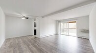 This single-floor, 2-bedroom, 2-bathroom unit offers a clean and functional layout designed for comfortable everyday living. The open living and dining area is finished with light gray wood-look vinyl flooring and features a ceiling fan, exposed beam detail, and a baseboard heating system. A sliding glass door connects the living space directly to a private balcony, filling the room with natural light and views of the surrounding landscape. The kitchen, visible from the living area, features dark cabinetry and provides a practical workspace.

The spacious primary bedroom is carpeted for comfort, includes a wall-mounted air conditioning unit, a closet with sliding doors, and a window overlooking a natural outdoor setting. The second bedroom also features wood-look vinyl flooring, a baseboard heater, and a window that brings in additional natural light.

Both bathrooms are finished in a clean, neutral palette. One bathroom includes a full tub-shower surround with white tile walls and wood-look vinyl flooring. The second bathroom offers a bright, minimalist design with modern chrome fixtures. Two closets throughout the unit provide ample storage. The overall aesthetic is bright, neutral, and move-in ready.