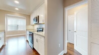 Located at 29 Linden St in Hackensack, NJ, this single-floor residence offers a well-designed layout with thoughtful finishes throughout. The galley-style kitchen is a standout feature, outfitted with white shaker cabinetry, granite-style countertops, and a full suite of stainless steel appliances including a refrigerator, electric range, built-in microwave, and dishwasher. Rich hardwood flooring flows continuously through the living areas and bedrooms, lending warmth and cohesion to the space. The living area benefits from a bay-style window configuration that invites generous natural light and creates an open, airy ambiance. Recessed lighting and neutral taupe-toned walls complement the bright, clean aesthetic throughout. Bedrooms are comfortably sized, each equipped with wall-unit HVAC and windows fitted with blinds for privacy and light control. The bathrooms are finished with large-format beige tile surrounds in the tub-shower combinations, warm wood-toned vanity cabinetry, white countertops, and tile flooring. The overall design balances functional living with clean, modern finishes, making this Hackensack residence a practical and comfortable home.