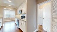 Located at 29 Linden St in Hackensack, NJ, this single-floor residence offers a well-designed layout with thoughtful finishes throughout. The galley-style kitchen is a standout feature, outfitted with white shaker cabinetry, granite-style countertops, and a full suite of stainless steel appliances including a refrigerator, electric range, built-in microwave, and dishwasher. Rich hardwood flooring flows continuously through the living areas and bedrooms, lending warmth and cohesion to the space. The living area benefits from a bay-style window configuration that invites generous natural light and creates an open, airy ambiance. Recessed lighting and neutral taupe-toned walls complement the bright, clean aesthetic throughout. Bedrooms are comfortably sized, each equipped with wall-unit HVAC and windows fitted with blinds for privacy and light control. The bathrooms are finished with large-format beige tile surrounds in the tub-shower combinations, warm wood-toned vanity cabinetry, white countertops, and tile flooring. The overall design balances functional living with clean, modern finishes, making this Hackensack residence a practical and comfortable home.