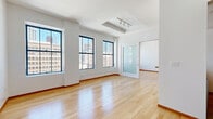 Located on the 10th floor of 541 S Spring St in the heart of Downtown Los Angeles, this one-bedroom, one-bathroom unit offers a well-designed urban living space with a clean, modern aesthetic throughout. Warm hardwood flooring extends across the living areas and bedroom, complemented by crisp white walls and rich wood baseboards that create a cohesive, polished look.

The open-concept kitchen and living area forms the heart of the unit. The kitchen features honey-toned wood cabinetry with glass-front upper panels, granite countertops, stainless steel appliances including a full-size refrigerator, and tile flooring. A peninsula counter provides a natural transition into the living area, maximizing the sense of openness.

Large, black-framed windows flood the living room with natural light and frame impressive views of the Downtown Los Angeles skyline, offering a dynamic urban backdrop. The bedroom continues the hardwood flooring and city views, and includes mirrored sliding closet doors that enhance the sense of space. A frosted glass sliding door adds a sleek, modern partition element.

The bathroom is finished with warm tile flooring, a wood-toned vanity with a stone countertop, a combined shower and bathtub with glass sliding doors, and a large mirror.