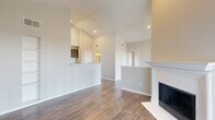 This thoughtfully designed single-floor residence offers a seamless blend of comfort and functionality across its well-utilized layout. The open-concept living and kitchen area serves as the heart of the home, anchored by a striking white-mantled fireplace beneath soaring vaulted ceilings that lend a sense of spaciousness well beyond the unit's footprint. Rich wood-look flooring runs throughout the main living areas, complemented by neutral wall tones that create a bright, welcoming ambiance. Large vertical-blind-covered sliding doors allow generous natural light to fill the living room.

The kitchen features dark cabinetry with modern hardware, stainless steel appliances including a refrigerator, range, and microwave, a classic subway tile backsplash, and a granite-topped breakfast bar that connects to the living space.

The generously sized bedroom is finished with plush carpet, crown molding, a ceiling fan, and a window offering natural light. It connects directly to a well-sized walk-in closet equipped with wire shelving and to the full bathroom, which boasts dual granite-topped sinks, dark cabinetry, a large mirror, and a separate tub and shower area.

A dedicated laundry area with side-by-side washer and dryer hookups rounds out the practical offerings of this well-designed home.