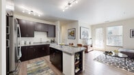 This thoughtfully designed 2-bedroom, 2-bathroom residence in Broomfield, Colorado offers a modern aesthetic with high-quality finishes throughout. The open-concept kitchen and living area serves as the heart of the home, anchored by a granite-topped island with bar seating and built-in shelving. Rich dark cabinetry contrasts elegantly with the granite countertops, while a full suite of stainless steel appliances — including a refrigerator, range, microwave, and dishwasher — completes the well-equipped kitchen. Light wood-style flooring flows through the main living areas, enhancing the bright, airy atmosphere. The living room offers generous natural light through large windows and a glass door, creating an inviting space with room for comfortable seating arrangements. Both bedrooms feature plush carpeting and ceiling fans, with the primary bedroom boasting a walk-in closet with wire shelving. A second closet provides additional storage. Each bathroom is finished with granite vanity countertops, dark cabinetry, a tub-shower combination, and wood-style flooring. Two dedicated closets add practical storage solutions throughout this well-planned Broomfield residence.