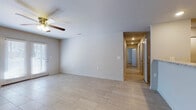 This single-floor, 2-bedroom, 2-bathroom residence offers a thoughtfully designed layout with a clean, neutral aesthetic throughout. The open living area is finished with large light-toned tile flooring and features a ceiling fan with integrated lighting. Natural light filters in through a set of French doors that lead to an outdoor patio area, enhancing the bright and airy feel of the main living space. A peninsula with granite-look countertops connects the living area to the kitchen, providing a natural divide while maintaining an open flow.

The kitchen is efficiently laid out with dark wood cabinetry, granite-style countertops, and a full suite of stainless steel appliances, including a gas range, built-in microwave, refrigerator, and dishwasher. Recessed lighting illuminates the space, and light tile flooring continues seamlessly from the main living area.

Both bedrooms are generously sized and carpeted in a warm neutral tone, each equipped with a ceiling fan and natural light from windows with blinds. The two bathrooms feature tile flooring, granite-style vanity countertops, and a clean, modern finish. A hallway connects the private quarters, maintaining a clear separation between living and sleeping areas. Overall, the home presents a functional and comfortable living environment with consistent finishes throughout.