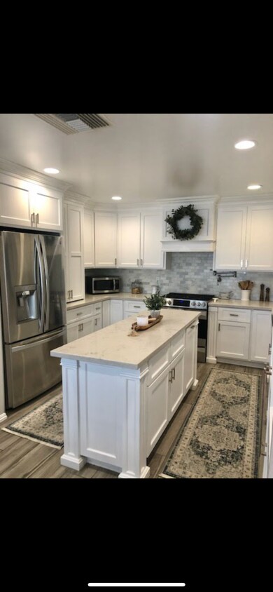 Cocina | Gabinetes personalizados de color blanco, encimeras de cuarzo, y placa para salpicaduras de mármol - 1835 Belmont Ct