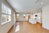 Located at 448 Denton Ave in Vacaville, CA, this thoughtfully designed two-story home offers four bedrooms and four bathrooms across two well-proportioned floors. The main level centers around a bright, open-concept living, dining, and kitchen area finished with warm hardwood-style flooring and recessed lighting throughout. The kitchen is a standout feature, showcasing crisp white cabinetry with matte black hardware, a herringbone tile backsplash, quartz countertops, stainless steel appliances, and a large center island with pendant lighting. Sliding glass doors lead directly to a private patio, filling the living area with abundant natural light and providing seamless indoor-outdoor flow. The main floor also includes a laundry room and an attached garage with a dedicated water heater utility space. Upstairs, four generously sized bedrooms feature hardwood-style flooring, ceiling fans, and large windows that invite natural light and outdoor views. The bathrooms are finished in a clean, contemporary style with white tile surrounds, quartz vanities, and matte black fixtures. Multiple closets throughout the home provide ample storage. Clean lines, a neutral color palette, and modern finishes give this home a cohesive, move-in-ready aesthetic.