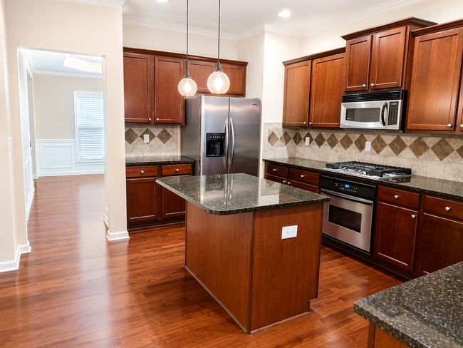 Bright eat-in kitchen featuring rich cherry wood cabinetry and ample storage. - 2143 Somerset Pl SE