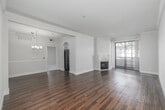 Located in the heart of Los Angeles on Burton Way, this well-appointed 2-bedroom, 2-bathroom residence offers a thoughtfully designed single-level layout. Distinctive arched doorways lend architectural character throughout, while rich hardwood flooring flows seamlessly across the main living areas. The combined living and dining space is anchored by a classic fireplace and illuminated by a stylish multi-light chandelier, creating an inviting atmosphere for both relaxing and entertaining. The kitchen features white cabinetry, light stone countertops, a double-basin sink, and tall arched windows that flood the space with abundant natural light. Both bedrooms are carpeted for comfort, with arched windows that bring in additional daylight. The spacious primary bedroom includes a dedicated walk-in closet with built-in shelving and dual hanging rods. Two full bathrooms are finished with white vanity cabinetry, vessel sinks, large mirrors, and hardwood-style flooring. A hallway connects the living areas to the private quarters. The residence also features a balcony with views of the surrounding Los Angeles neighborhood, perfect for enjoying the Southern California climate. Crown molding and clean white walls throughout add a polished, cohesive finish to this centrally located home.