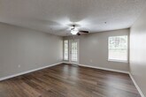 Located in Charlotte, NC, this thoughtfully designed 1-bedroom, 1-bathroom home offers a comfortable and functional layout across a single floor. The open-concept living and dining area is a standout feature, showcasing rich dark hardwood-style flooring, neutral gray walls, a textured ceiling, and a ceiling fan that enhances airflow and comfort. Multiple windows, including a set of glass-panel doors, flood the space with natural light and provide views of the surrounding greenery outdoors.

The kitchen is well-equipped with dark espresso cabinetry, granite-style countertops, stainless steel appliances including a refrigerator, electric range, and over-the-range microwave, along with a sink with ample counter space. Conveniently accessible from the kitchen is an in-unit laundry area with a full-size washer and dryer.

The bedroom is a comfortable retreat featuring plush carpeting, a ceiling fan, a window with outdoor views, and direct access to a walk-in closet outfitted with wire shelving for organized storage. The full bathroom is clean and modern, featuring wood-style flooring, a granite-top vanity with dark cabinetry, and a tub-shower combination with tile surround.