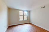 Located at 1550 7th Street Northwest in Washington, DC, this 2-bedroom, 2-bathroom unit offers a well-designed single-level layout. The kitchen is a standout feature, showcasing rich warm-toned wood cabinetry, granite countertops with a peninsula, and stainless steel appliances including a range, microwave, and refrigerator — all set atop durable hardwood flooring that extends into the main living areas. The hallways connect the spaces efficiently, contributing to a cohesive flow throughout. Both bedrooms are carpeted for comfort and receive natural light through large windows; the primary bedroom benefits from dual windows with leafy outdoor views and features two double-door closets, providing generous storage. The second bedroom also offers natural light with views of the surrounding streetscape. The two full bathrooms are well-appointed, each featuring subway tile tub-and-shower surrounds with brushed nickel fixtures. One bathroom includes a deep soaking tub, while the other features a granite vanity countertop with warm wood cabinetry and tile flooring. The neutral color palette and clean finishes throughout give the space a bright, move-in-ready feel well-suited for urban living in the heart of Washington, DC.