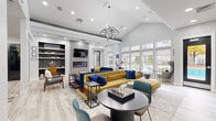 Located at 12167 Lincoln Lake Way in Fairfax, Virginia, this single-floor community clubhouse delivers a sophisticated blend of modern design and functional amenities. The welcoming entryway features light wood-look flooring, a geometric chandelier, a coffered ceiling, and black-framed glass doors that set an elegant tone throughout.

The expansive main lounge is the centerpiece of the space, showcasing soaring vaulted ceilings, a striking multi-arm chandelier, and a wall of large windows that flood the room with natural light and offer views of the outdoor pool area. Bold, jewel-toned furnishings—including royal blue and mustard yellow sectional sofas—are anchored by a patterned area rug, while a linear electric fireplace with built-in shelving adds warmth and visual interest. Decorative accent walls and sculptural wall art contribute to the curated, upscale aesthetic.

The fully equipped kitchen features crisp white cabinetry, quartz countertops with black hardware accents, stainless and matte black appliances, and a spacious island with bar seating beneath globe pendant lights. A black-framed interior window connects the kitchen to adjacent spaces, adding an architectural detail that enhances the open flow.

A dedicated workspace area with built-in shelving and a desk nook provides a quiet retreat for focused work, completing this well-appointed community gathering space.