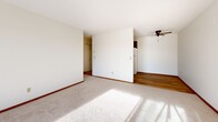 Located at 4601 Shoreline Drive in Spring Park, Minnesota, this one-bedroom, one-bathroom residence offers a practical and well-organized single-floor layout. The living room is a bright, open space featuring plush carpet, warm wood trim, a ceiling fan, and a large sliding glass door that fills the room with natural light and provides views of the surrounding outdoor scenery. The combined dining and kitchen area is thoughtfully arranged, featuring wood-toned cabinetry, a double-basin sink, light countertops, and hardwood flooring that transitions seamlessly from the kitchen into the adjoining spaces. The bedroom is a comfortably sized retreat with carpet, a ceiling fan, a dedicated window for natural light, and access to a spacious closet equipped with a wood hang rod and multiple hooks for ample storage. Two additional closets provide further organization throughout the unit. The bathroom is clean and functional, featuring a full tub and shower combination with classic white tile accents, a mosaic tile floor, and a white vanity with under-sink cabinetry. A connecting hallway ties the rooms together efficiently, completing the cohesive and practical flow of this well-maintained residence.