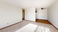 Located at 4601 Shoreline Drive in Spring Park, Minnesota, this one-bedroom, one-bathroom residence offers a practical and well-organized single-floor layout. The living room is a bright, open space featuring plush carpet, warm wood trim, a ceiling fan, and a large sliding glass door that fills the room with natural light and provides views of the surrounding outdoor scenery. The combined dining and kitchen area is thoughtfully arranged, featuring wood-toned cabinetry, a double-basin sink, light countertops, and hardwood flooring that transitions seamlessly from the kitchen into the adjoining spaces. The bedroom is a comfortably sized retreat with carpet, a ceiling fan, a dedicated window for natural light, and access to a spacious closet equipped with a wood hang rod and multiple hooks for ample storage. Two additional closets provide further organization throughout the unit. The bathroom is clean and functional, featuring a full tub and shower combination with classic white tile accents, a mosaic tile floor, and a white vanity with under-sink cabinetry. A connecting hallway ties the rooms together efficiently, completing the cohesive and practical flow of this well-maintained residence.