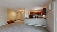 Located at 1703 Forest Cove Dr in Mount Prospect, IL, this 2-bedroom, 1-bathroom residence offers a well-organized and functional floor plan. The open living area is generously sized, featuring neutral-toned carpet, a ceiling fan, and large sliding glass doors that lead to a private balcony overlooking lush greenery, filling the space with natural light.

The kitchen is semi-open to the living area via a pass-through counter and is equipped with rich, warm-toned cabinetry, stone-look countertops, black appliances including a range, refrigerator, and microwave, and hardwood flooring. A window above the sink brings in additional natural light.

The primary bedroom is a comfortable retreat, offering two closets with built-in shelving, a window with outdoor views, and its own wall AC unit. The second bedroom is cozy with carpeted flooring and baseboard heating. Both bedrooms are carpeted and well-lit.

The bathroom features a tiled tub/shower combination, hardwood-style flooring, and a clean, straightforward layout. Throughout the residence, baseboard heating is present in multiple rooms. Ceiling fans in the living and entry areas add to the overall comfort. The entry foyer provides a welcoming transition into the home.
