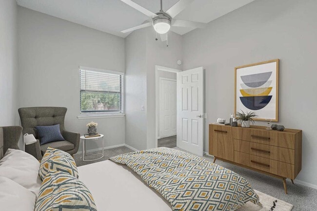 Bedroom with ceiling fan, patterned bedding, gray accent chair, wood dresser, framed wall art, and carpet flooring - Walnut Creek at 122