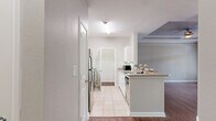 Located in Plano, TX, this well-designed one-bedroom, one-bathroom residence offers a thoughtful layout across a single floor, making efficient use of its compact footprint. The kitchen is a standout feature, showcasing white cabinetry, granite-style countertops, a stainless steel refrigerator, and a full suite of appliances including a range and dishwasher. Light tile flooring runs throughout the kitchen, which also benefits from a breakfast bar countertop — ideal for casual dining. A dedicated laundry area is conveniently accessible directly from the kitchen. The bedroom is a comfortable, carpeted retreat featuring warm neutral tones, a ceiling fan, and a window with blinds that invites natural light and views of the surrounding area. A dedicated closet provides ample storage. The bathroom is clean and functional, outfitted with tile flooring, a white vanity with ample drawer storage, a large mirror, and a toilet, all finished in a light, neutral palette. Throughout the residence, neutral wall tones and consistent finishes create a cohesive, move-in-ready aesthetic. Situated in the desirable Plano, TX area, this residence combines practical amenities with a clean, modern design.
