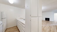 Located in the Westwood neighborhood of Los Angeles, this 2-bedroom, 2-bathroom residence offers a well-organized single-level layout with a clean, bright aesthetic throughout. Light wood-plank flooring flows seamlessly across every room, complemented by crisp white walls and textured ceilings that lend a consistent, airy feel to the space.

The living room serves as the heart of the home, featuring a wood-burning fireplace and a floor-to-ceiling sliding glass door that opens onto a private balcony, filling the room with natural light and providing outdoor views of the surrounding neighborhood.

The galley-style kitchen is efficiently designed with white cabinetry, a gas range, refrigerator, and ample counter space along both sides, maximizing functionality within a compact footprint. A tall pantry cabinet adds generous storage just off the kitchen.

Both bedrooms are generously proportioned, with the primary bedroom offering comfortable living space, a dedicated closet, and access to natural light. The second bedroom features a large window framing outdoor greenery. Each bedroom is served by its own bathroom — one with a tub-shower combo behind sliding glass doors, and the other with a wide vanity, large mirror, and a separate water closet. A hallway and two closets provide additional storage throughout.