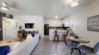 This single-story, three-bedroom, two-bathroom home in Tucson, AZ offers a well-designed open-concept layout that efficiently connects the living, dining, and kitchen areas. Wood-look plank flooring runs throughout, providing a cohesive, low-maintenance aesthetic across every room.

The living room features vaulted ceilings, a ceiling fan, a bold accent wall, and sliding glass doors that open to an outdoor patio, bringing in natural light and outdoor views. The kitchen is appointed with white shaker cabinetry, granite-style countertops, black appliances including a range, microwave, refrigerator, and dishwasher, and pendant lighting above a peninsula that doubles as a breakfast bar. A dedicated dining area with a window sits adjacent to the kitchen.

The generously sized primary bedroom includes a ceiling fan, windows on two walls, a bold accent wall, and access to a walk-in closet. The en-suite bathroom features a walk-in shower. Two additional bedrooms provide flexible use. A dedicated laundry room houses a full-size washer and dryer. Two full bathrooms serve the home, and a hallway connects the private bedroom wing to the main living spaces.