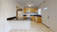 Located at 1168 Highland Ave in Fall River, Massachusetts, this two-story home offers a thoughtfully designed layout across two well-defined floors. The entry level welcomes visitors through a front door with a transom window, opening into a foyer with durable hardwood-style laminate flooring that extends into a spacious living area. A staircase with a classic wood banister and white spindles leads to the upper level, adding a traditional touch to the interior.

The kitchen is a functional highlight of the main floor, featuring light wood cabinetry, dark granite countertops, and a central peninsula that provides additional workspace. Tile flooring, a gas range, built-in microwave, dishwasher, and ample storage make this kitchen both practical and efficient. Natural light filters in through a window above the sink, brightening the space.

Upstairs, the bedrooms are finished with plush carpeting and neutral walls, each benefiting from windows that overlook the surrounding neighborhood. Ceiling fans are present in multiple rooms, contributing to year-round comfort. One room also features a wall-mounted air conditioning unit for added climate control.

The bathroom is clean and bright, finished with white tile surround and a bathtub with a frosted privacy window. Throughout the home, the design emphasizes simplicity, functionality, and comfort in a residential Fall River setting.