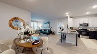 This well-appointed single-floor residence offers a thoughtfully designed open-concept layout that seamlessly connects the living, dining, and kitchen areas. Light wood-style flooring runs throughout the main living spaces, creating a bright and cohesive feel. The kitchen is a standout feature, showcasing two-tone cabinetry with crisp white upper cabinets and dark lower cabinets, granite countertops, a herringbone tile backsplash, stainless steel appliances, and a peninsula with bar seating — ideal for casual dining or entertaining. The adjacent dining area provides a dedicated space for formal meals, while the living room offers generous proportions, large windows, and a private exterior door that fills the room with natural light. Both bedrooms are carpeted for comfort and feature large windows with ample natural light. The primary bedroom is particularly spacious, offering room for a king-sized bed and peaceful garden views. The bathroom is finished with granite countertops, dark cabinetry with gold hardware, a backlit vanity mirror, and tile flooring. Throughout the home, neutral tones and modern finishes create a clean, contemporary ambiance suitable for a variety of lifestyles.