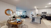 This well-appointed single-floor residence offers a thoughtfully designed open-concept layout that seamlessly connects the living, dining, and kitchen areas. Light wood-style flooring runs throughout the main living spaces, creating a bright and cohesive feel. The kitchen is a standout feature, showcasing two-tone cabinetry with crisp white upper cabinets and dark lower cabinets, granite countertops, a herringbone tile backsplash, stainless steel appliances, and a peninsula with bar seating — ideal for casual dining or entertaining. The adjacent dining area provides a dedicated space for formal meals, while the living room offers generous proportions, large windows, and a private exterior door that fills the room with natural light. Both bedrooms are carpeted for comfort and feature large windows with ample natural light. The primary bedroom is particularly spacious, offering room for a king-sized bed and peaceful garden views. The bathroom is finished with granite countertops, dark cabinetry with gold hardware, a backlit vanity mirror, and tile flooring. Throughout the home, neutral tones and modern finishes create a clean, contemporary ambiance suitable for a variety of lifestyles.