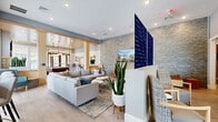 Located at 645 Daniel Webster Highway in Merrimack, New Hampshire, this single-floor community amenity space offers a diverse range of well-designed areas totaling nearly 2,000 square feet. The welcoming entrance hallway opens into a bright, open living lounge featuring a striking stacked-stone accent wall, a wall-mounted display, and comfortable seating arrangements in warm tones, creating an inviting gathering area. Adjacent, a spacious game and recreation room boasts a wood-paneled ceiling, a classic stone fireplace, large windows that flood the space with natural light, and a full-size pool table, with French doors providing views of the outdoor area. A cozy screening room, complete with theater-style seating, decorative movie posters, and a classic popcorn machine, offers an entertaining retreat. The compact kitchen features light wood cabinetry, stainless steel appliances, a coffee station, and tile flooring with ample natural light. Two dedicated office spaces serve distinct functions: one is a bright, windowed room ideal for small meetings, and the other offers a private workspace with modern artwork and light wood flooring. Connecting hallways maintain a clean, contemporary aesthetic throughout, tying all areas together cohesively.