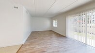 Located at 5701 6th Ave N in Saint Petersburg, FL, this single-floor, one-bedroom, one-bathroom residence offers a well-organized layout across five distinct spaces: a living room, bedroom, kitchen, hallway, and bathroom.

The living room is bright and open, featuring light wood-style laminate flooring, neutral white walls, and a sliding glass door fitted with vertical blinds that allows natural light to pour in while providing access to an outdoor area. A window on the adjacent wall further enhances the airy feel of the space.

The kitchen is clean and functional, finished with light ceramic tile flooring, white raised-panel cabinetry, a tile backsplash, a double-basin sink, and white appliances including a refrigerator and electric range. A window above the range brings in additional natural light. A louvered bifold closet door in the kitchen area provides convenient storage.

The bedroom is a comfortable, well-proportioned space with the same light wood-style laminate flooring as the living area. It features a large louvered bifold closet spanning much of one wall and a window that allows natural light in.

The bathroom is finished with light ceramic tile flooring and includes a white vanity with a quartz-style countertop, a toilet, and a tub/shower combination with tile surround. The hallway connects all rooms in a practical flow throughout the unit.