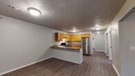 Located at 124 Hamlet Rd in Branson, Missouri, this single-floor unit offers a practical and comfortable layout designed for everyday living. The open-concept design connects the kitchen and living area seamlessly, creating a spacious, functional environment. The kitchen is well-equipped with warm honey-toned wood cabinetry offering generous storage, granite-style countertops, a stainless steel refrigerator, and a stainless steel range. A peninsula counter serves as a natural divider between the kitchen and the open living space, providing additional workspace or casual dining. Durable wood-style vinyl flooring runs throughout the main living areas, offering both aesthetic appeal and easy maintenance. The bedrooms are comfortably sized with neutral gray walls and the same wood-style flooring, and at least one bedroom features a built-in closet with sliding panel doors. The bathrooms are fitted with oak-toned vanities topped with granite-style countertops, large mirrors, and matching fixtures, maintaining a consistent design theme throughout. Textured ceilings and flush-mount lighting are found across the unit. The overall ambiance is clean, neutral, and move-in ready, making this Branson property a practical choice for a variety of occupants.