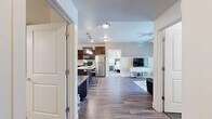 Located in South Ogden, Utah, this thoughtfully designed 2-bedroom, 2-bathroom residence offers a comfortable and functional single-level layout. The open-concept living room features wood-style flooring, a ceiling fan, and a sliding glass door that fills the space with natural light and provides access to an outdoor patio. The kitchen is a standout feature, boasting rich dark-wood cabinetry, white quartz countertops, a central island with pendant lighting and bar seating, a double-basin stainless steel sink, a stainless dishwasher, and a gas range — ideal for everyday cooking and entertaining. Both bathrooms are finished with matching dark-wood vanities, white countertops, and wood-style tile flooring, with one bathroom conveniently housing in-unit washer and dryer hookups. The primary bedroom is generously sized with soft carpeting and a large window, while the second bedroom also features plush carpet, a bright window, and ample natural light. A dedicated closet provides additional storage. Throughout the residence, neutral tones and clean finishes create a cohesive, move-in-ready aesthetic that is both practical and inviting.