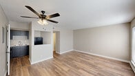 Located at 3708 Garden Oaks Dr in New Orleans, LA, this single-story, 3-bedroom, 1-bathroom home offers a practical and comfortable layout. The open living room and kitchen area is anchored by warm wood-look flooring, neutral taupe walls, and a ceiling fan with light fixture, creating a bright and airy atmosphere. A built-in pass-through niche connects the living space to the kitchen, which is outfitted with dark shaker-style cabinetry, marble-look countertops, a double stainless steel sink, and black appliances including an electric range — a functional and stylish combination. A central hallway connects the living areas to the three bedrooms and shared bathroom. The bedrooms feature plush carpeting, neutral walls, and ample natural light from blinds-covered windows. Each bedroom includes a closet with built-in shelving. The shared full bathroom features a clean, white tub-shower combination. Throughout the home, white trim and baseboards complement the neutral palette, lending a cohesive and well-maintained appearance. The efficient floor plan makes thoughtful use of every square foot, offering comfortable living across all rooms.