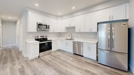 Located at 2210 Rock St in Mountain View, California, this thoughtfully designed 2-bedroom, 1-bathroom unit offers a clean, modern aesthetic across a single floor. Light-toned, wood-look luxury vinyl plank flooring runs throughout the entire space, creating a cohesive and contemporary feel.

The kitchen is a standout feature, showcasing crisp white shaker cabinetry, quartz countertops, and a full suite of stainless steel appliances including an electric range, over-the-range microwave, dishwasher, and a French door refrigerator. Recessed lighting illuminates the space efficiently.

Both bedrooms are bright and comfortable, each equipped with a wall-mounted mini-split system for individual climate control and windows that invite natural light. The primary bedroom offers a generous footprint, while the second bedroom features exposed beam-style architectural details that add character. Each bedroom benefits from dedicated closet space.

The bathroom is finished to a high standard, featuring elegant marble-look tile surrounds in the tub/shower combination, brushed nickel fixtures, white cabinetry, and matching quartz countertops — maintaining the refined aesthetic found throughout the home.

The entryway is open and welcoming, with recessed lighting and neutral gray walls that complement the light flooring. Overall, the unit presents a fresh, move-in-ready interior with consistent, modern finishes from room to room.