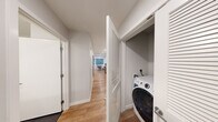 Located on Harvard Avenue in Seattle's Capitol Hill neighborhood, this one-bedroom, one-bathroom unit offers a thoughtfully designed layout across a single floor. Light-toned hardwood-style flooring runs throughout the main living areas, tying the space together with a clean, modern aesthetic.

The living room is bright and open, featuring recessed lighting, a wall-mounted mini-split HVAC unit for year-round comfort, and windows that bring in natural light. The space comfortably accommodates both a seating area and a dining setup, making it highly functional.

The kitchen is finished with white upper cabinetry, dark lower cabinetry, and white quartz countertops. A tile backsplash, stainless steel electric range, and stainless steel refrigerator complete the contemporary kitchen package, offering a polished and practical cooking space.

The bedroom is a well-proportioned, quiet retreat with neutral walls, hardwood-style flooring, and its own wall-mounted mini-split unit for individualized climate control. A hallway off the main corridor features a dedicated in-unit washer closet with louvered doors, adding significant everyday convenience.

The bathroom features a clean, minimalist design with dark tile flooring, a vanity with storage, and chrome hardware. Crisp white walls and simple fixtures keep the space feeling fresh and functional throughout.