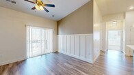 Located in South Ogden, Utah, this 2-bedroom, 2-bathroom residence offers a thoughtfully designed single-floor layout that maximizes comfort and functionality. The open-concept kitchen and living area serves as the heart of the home, where rich dark-stained cabinetry, a central island with a white countertop, stainless steel appliances, and pendant lighting combine to create a stylish and practical space. Wood-look flooring flows throughout the main living areas, complementing the neutral, light-toned walls. The living room features vaulted ceilings, a ceiling fan, and a sliding glass door that fills the space with natural light and provides outdoor access. Both bedrooms are carpeted and generously proportioned, with the primary bedroom offering impressive walk-in closet space equipped with dual hanging rods. The second bedroom benefits from multiple windows with views of the surrounding mountains and neighborhood. Each bathroom is finished with wood-look flooring, a tub-shower combo with a curved curtain rod, and brushed nickel fixtures. Additional conveniences include two closets, two hallways for efficient circulation, and a smart thermostat panel near the entryway. The clean, neutral palette and modern finishes throughout create a cohesive and move-in-ready atmosphere.