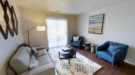Located at 2223 East 151st Street in Carmel, Indiana, this single-floor residence offers a well-designed layout ideal for comfortable everyday living. The living area serves as the heart of the space, showcasing warm hardwood-style flooring that adds a rich, inviting tone throughout. A large sliding glass door with vertical blinds allows abundant natural light to fill the room while providing direct access to the outdoors, creating a seamless connection between interior and exterior. The textured ceiling adds a classic architectural detail that complements the neutral wall tones. The living space is generously proportioned, accommodating a full seating arrangement with ease, and features a layout that encourages both relaxation and social interaction. Colorful wall art brings a vibrant focal point to the room, adding personality and visual interest. The overall ambiance is bright, clean, and modern, with a neutral palette that provides a versatile backdrop for a variety of interior styles. Situated in the desirable Carmel, Indiana community, this residence benefits from a well-established neighborhood known for its accessibility and quality of life.