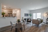 Located at 1200 Felix Way in Westampton, NJ, this well-appointed one-bedroom, one-bathroom residence offers a thoughtfully designed single-floor layout with modern finishes throughout. The open-concept living and dining area is bright and inviting, featuring light-toned hardwood-style flooring, recessed lighting, and a sliding glass door that fills the space with natural light and leads to a private balcony. The living room comfortably accommodates both a lounge and a home office setup, creating a versatile and functional space. The galley-style kitchen is efficiently designed with gray shaker cabinetry, white quartz countertops, a stainless steel sink, and a full suite of stainless steel appliances, including a gas range, microwave, and refrigerator. The spacious primary bedroom features plush carpeting, multiple windows with natural light, a walk-in closet, and direct access to the bathroom. The bathroom is finished with marble-look tile flooring, a neutral-toned vanity with a large mirror, a soaking tub and shower combination, and a bright window. Clean white walls and a cohesive neutral palette throughout lend the space a contemporary, move-in-ready aesthetic.