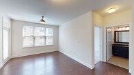 Located at 749 Ninth St in Durham, NC, this single-floor residence offers a thoughtfully designed layout with contemporary finishes and a clean, modern aesthetic throughout. The kitchen is a standout feature, boasting dark espresso cabinetry that reaches to the ceiling, granite countertops, a mosaic tile backsplash, stainless steel appliances including a refrigerator with ice maker, range, microwave, and dishwasher, plus a generous island with pendant lighting — ideal for both cooking and entertaining. Rich hardwood flooring flows through the main living and kitchen areas, adding warmth and contrast to the crisp white walls. The living space is bright and open, with a ceiling fan and access to a private balcony through a glass-paneled door, allowing for natural light and outdoor views. The bedrooms feature soft carpeting, ceiling fans, and wide windows fitted with blinds that invite ample natural light. The bathrooms are elegantly appointed with dark vanity cabinetry, granite countertops, and large framed mirrors. The primary bath includes a double-sink vanity and a separate walk-in shower with tile surround, while the secondary bath offers a tub-shower combination. The space presents a cohesive blend of comfort and modern style throughout.